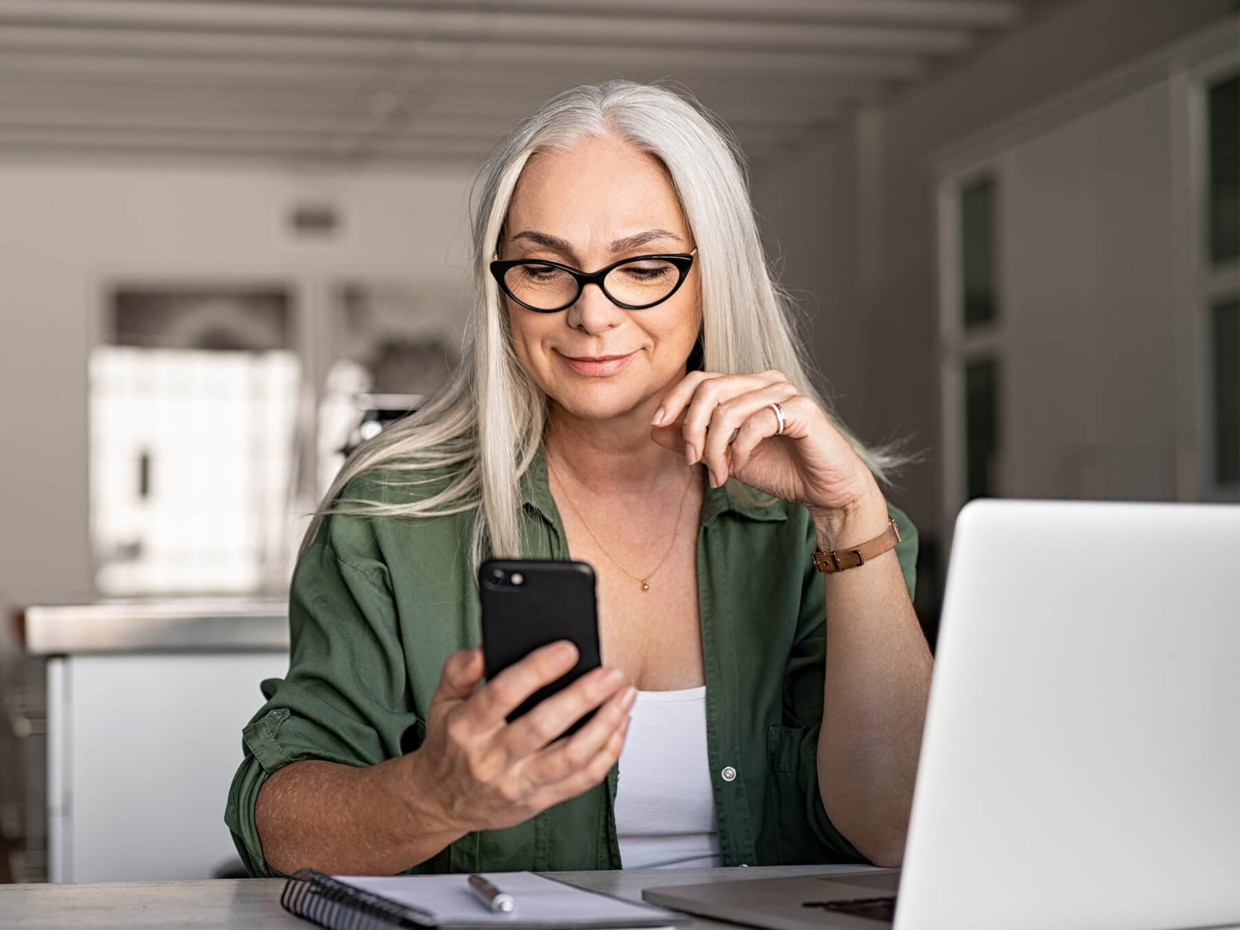 Professional female CPA in her home office on phone and laptop